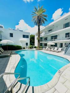 uma piscina em frente a um edifício com uma palmeira em Aqua Hotel em Fort Lauderdale