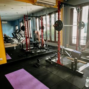 un hombre haciendo ejercicio en un gimnasio con pesas en Le Charme Vientiane Hotel, en Vientiane