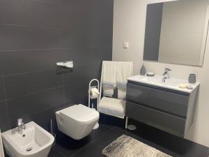 een badkamer met een wit toilet en een wastafel bij AL Florence in Setúbal