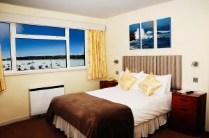 una camera d'albergo con un letto e due finestre di Dolphin Hotel a Gorey