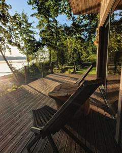 une terrasse en bois avec un banc sur le côté d'une maison dans l'établissement Lapsu ciems, à Sece