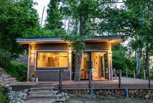 une petite maison dans les bois avec une terrasse dans l'établissement Lapsu ciems, à Sece