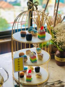 una mostra a tre livelli di cupcake e muffin di Happy Life Grand Hotel & Rooftop Skybar ad Ho Chi Minh