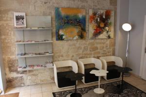 a room with chairs and a table and some paintings at Hotel Excelsior in Paris