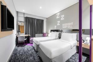 ドバイにあるStudio M Arabian Plaza Hotel & Hotel Apartmentsのベッド2台とテレビが備わるホテルルームです。