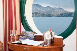 a table with a window with a view of the water at Relais Casali della Cisterna in Belgirate