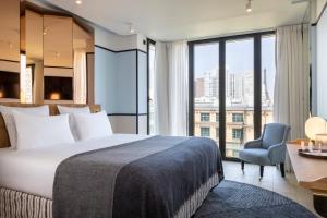 a bedroom with a large bed and a desk and a chair at Quinzerie hôtel in Paris