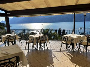 - un restaurant avec des tables et des chaises et une vue sur l'océan dans l'établissement Hotel Capri, à Malcesine