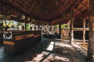 un restaurante con un bar en un techo de paja en Radhoo Tulum, en Tulum