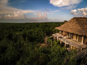 una casa antigua con techo de paja en un campo en Radhoo Tulum, en Tulum