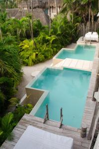 - une piscine d'eau bleue dans un complexe dans l'établissement La Valise Tulum, member of Small Luxury Hotels, à Tulum