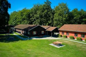 eine Gruppe von Gebäuden mit einer Bank im Gras in der Unterkunft Danhostel Hillerød in Hillerød