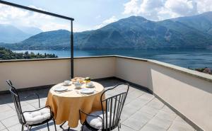 a table on a balcony with a view of a lake at Hotel La Perla in Tremezzo