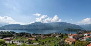 a view of a town and a lake with mountains at Hotel La Perla in Tremezzo