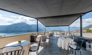 a restaurant with tables and chairs and a view of the ocean at Hotel La Perla in Tremezzo