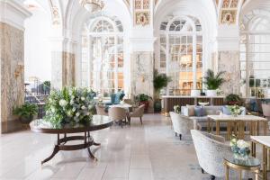 een lobby met tafels en stoelen in een gebouw bij The Hermitage Hotel in Nashville