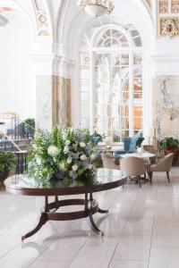 een lobby met een tafel met een boeket bloemen erop bij The Hermitage Hotel in Nashville