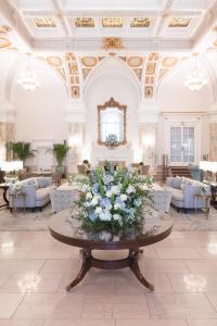 een lobby met een tafel met bloemen erop bij The Hermitage Hotel in Nashville