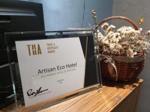 a basket of flowers sitting on a table with a sign at Artisan Eco Hotel in Petaling Jaya