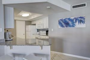 a kitchen with white cabinets and a counter top at El Matador 454 - Beautiful views of the Gulf and pool - Includes seasonal beach service! in Fort Walton Beach