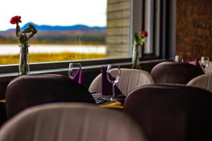 une table avec des chaises, des verres à vin et une fenêtre dans l'établissement Hotel Kriunes, à Reykjavik