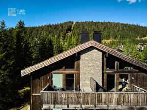 a log cabin in the mountains with trees at Apartment with Electric car charger ski in out in Sjusjøen