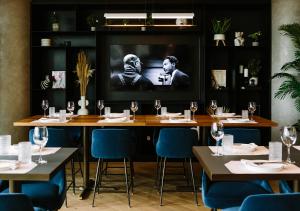 een eetkamer met tafels en een tv aan de muur bij Hotel X Toronto by Library Hotel Collection in Toronto