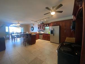 a kitchen with a refrigerator and a table with chairs at Los Porticos in Placencia Village