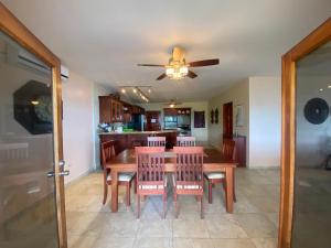 a dining room with a table and chairs and a ceiling fan at Los Porticos in Placencia Village