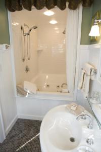 ein Badezimmer mit einem Waschbecken und einer Badewanne in der Unterkunft The Belvedere Inn & Restaurant in Saugatuck