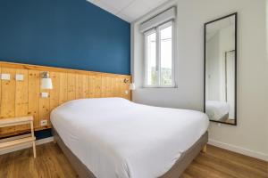 ein großes weißes Bett in einem Zimmer mit blauer Wand in der Unterkunft Le Relais de la Calèche in Le Beausset