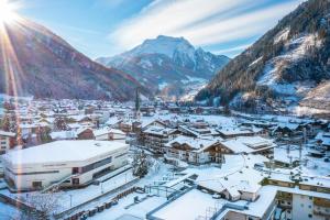 迈尔霍芬Hotel Berghof Mayrhofen GmbH的一座被雪覆盖的小镇,以群山为背景