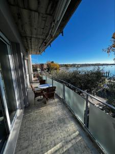 een balkon met een tafel en stoelen en uitzicht op het water bij Front Lake Apartment Bardolino in Bardolino