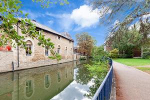 un canale di fronte a un edificio con riflesso nell'acqua di La casetta d’Àneu, Oxford Castle a Oxford