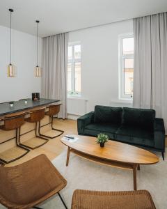 a living room with a green couch and a table at Luxury wellness apartment SHA in Osijek