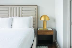 een slaapkamer met een bed en een lamp op een nachtkastje bij Drey Hotel in Dallas