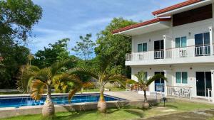 une maison avec des palmiers en face d'une piscine dans l'établissement Villa del OZ Resort, à Panglao