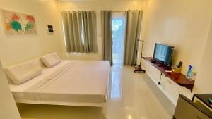 - une chambre avec un grand lit et une télévision dans l'établissement Villa del OZ Resort, à Panglao