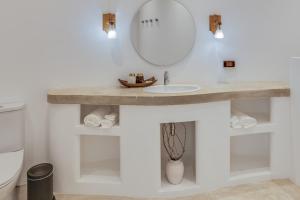 La salle de bains est pourvue d'un lavabo et d'un miroir. dans l'établissement Ampersand Resort, à Bophut 