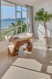 - une table basse en bois dans un salon avec une plante dans l'établissement Ampersand Resort, à Bophut 