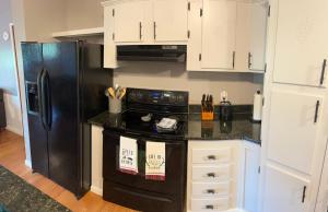 a kitchen with a black stove and a refrigerator at Bear Doodle 2.0 in Sevierville