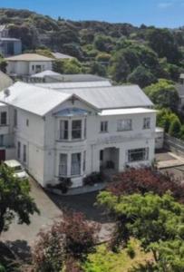 a large white house with a roof at Travel Stay City Hostel in Dunedin