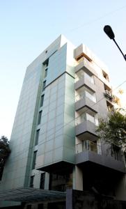 un grand bâtiment en verre avec un balcon dans l'établissement Quality Inn Mint, à Pune