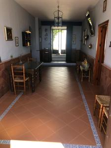 Habitación con suelo de baldosa, mesa y sillas. en Cortijo Ribero, en Cabra