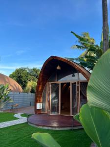 una casa circular con un arco en un jardín en Found Mansion, en Pantai Cenang