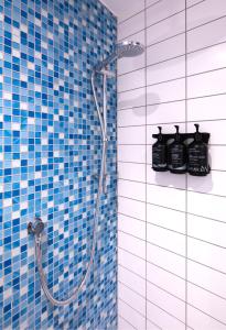 a bathroom with a shower with blue tiles at Holiday Inn Sunderland - City Centre, an IHG Hotel in Sunderland