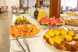 uma mesa coberta com pratos de frutas e sobremesas em Blumenau Tower by Castelo Itaipava em Blumenau