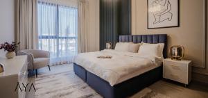 ein Schlafzimmer mit einem Bett, einem Stuhl und einem Fenster in der Unterkunft Luxurious Garden View Apartment with Pool & Gym in Madinat Jumeirah in Dubai