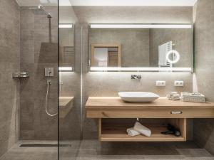 a bathroom with a sink and a shower at Hotel Magdalena Mayrhofen in Mayrhofen