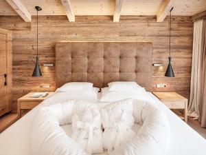 a bedroom with a large white bed with wooden walls at Hotel Magdalena Mayrhofen in Mayrhofen